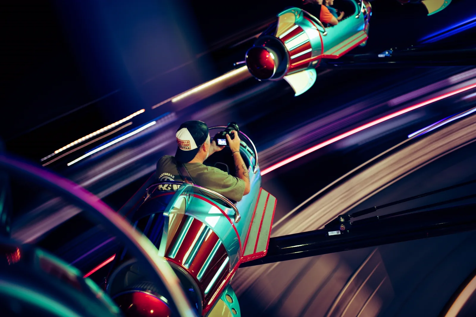 The Amazing Adventures of Spider-Man: A person taking a photo while riding a retro rocket ship amusement ride in motion.