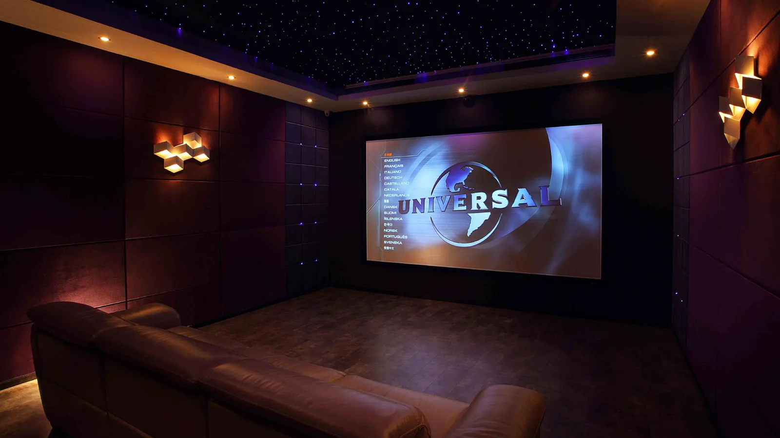 Universal Studios Florida: A modern private movie theater room featuring a large projection screen and leather couch.
