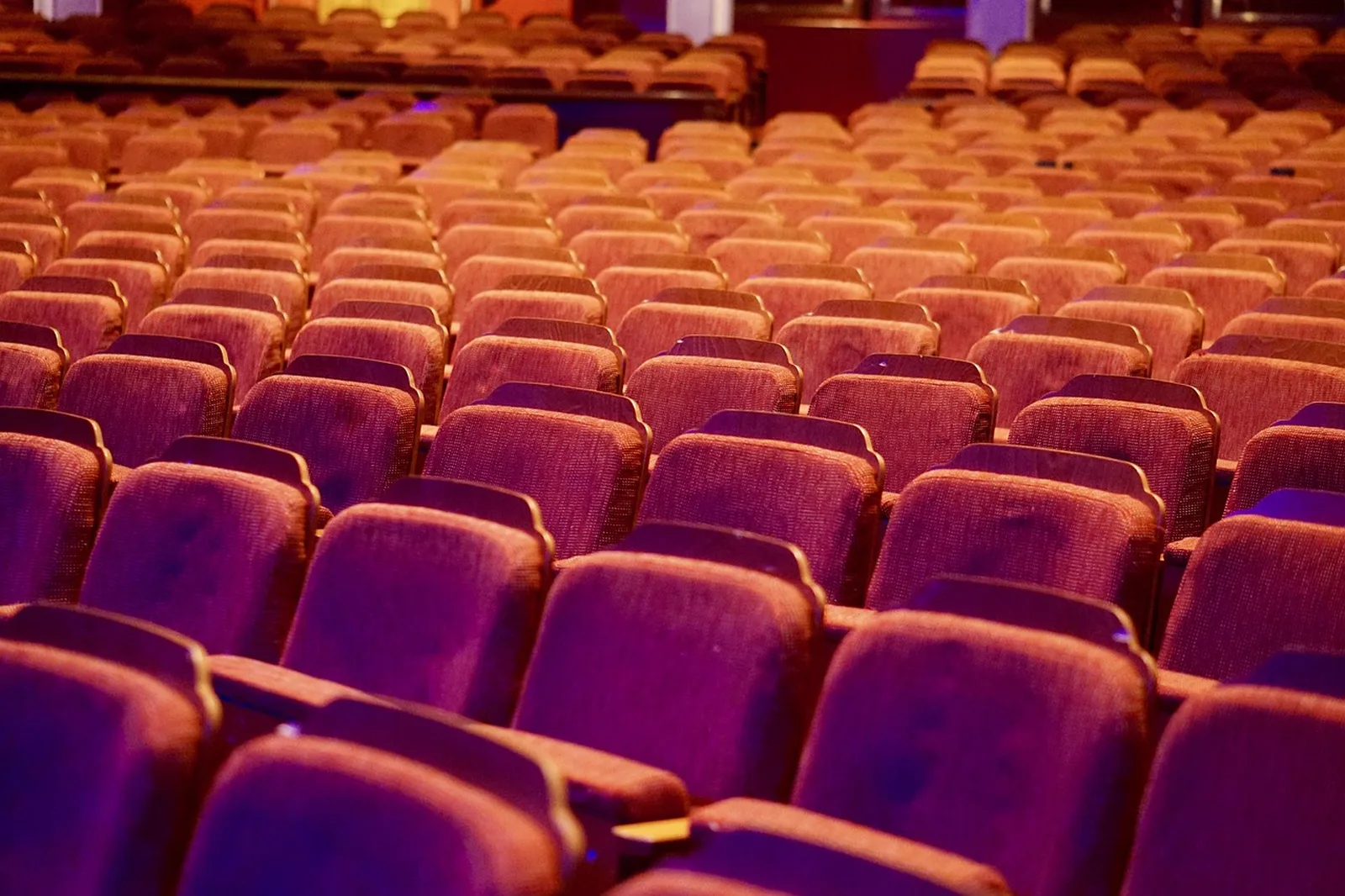 Soarin' Around the World: Rows of empty red plush seats in a cinema auditorium.