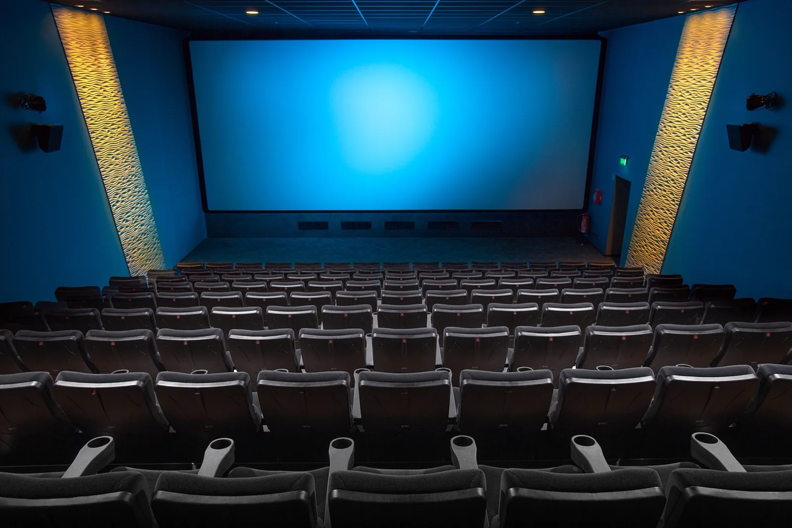 The Simpsons Ride: An empty movie theater auditorium facing a glowing blue screen.