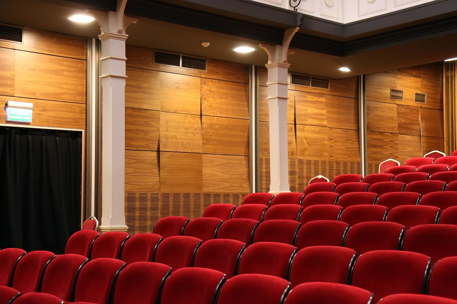Astronaut Training Experience (ATX): Rows of empty red seats inside a theater with wood-paneled walls.