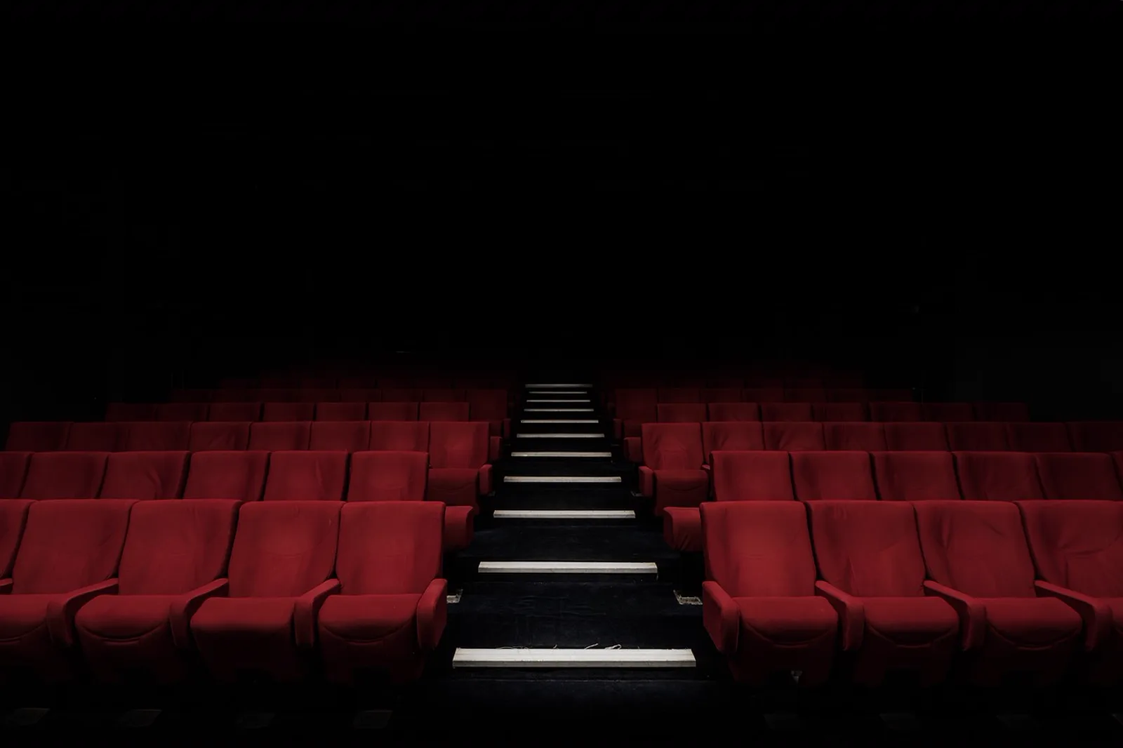 Heroes and Legends: Rows of empty red seats in a dark movie theater.