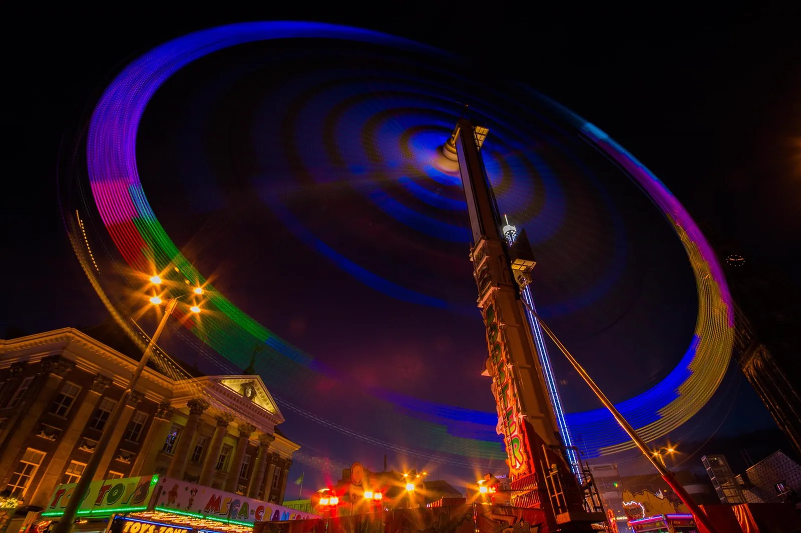 Captain Cranky's Challenge: A long exposure photograph of a colorful spinning fairground ride lit up at night.
