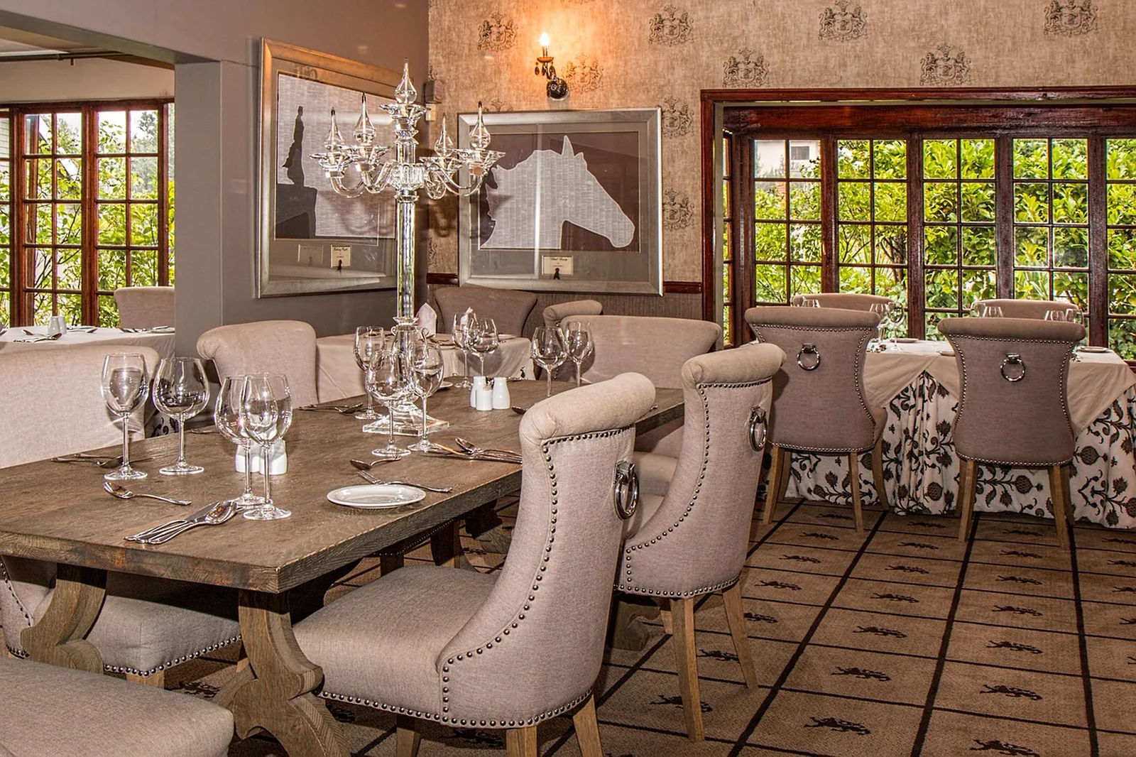 The BOATHOUSE: An elegant restaurant dining room featuring a set wooden table with glass candelabra and wine glasses.
