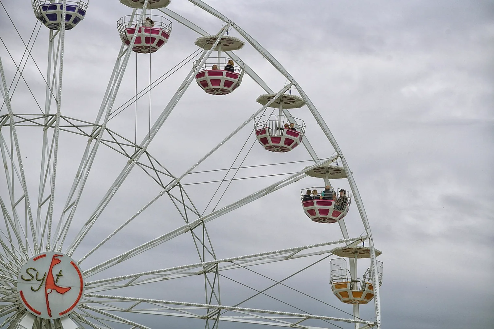 Peppa's Pedal Bike Tour and George's Tricycle Trail: A large Ferris wheel with pink and white gondolas against an overcast sky.