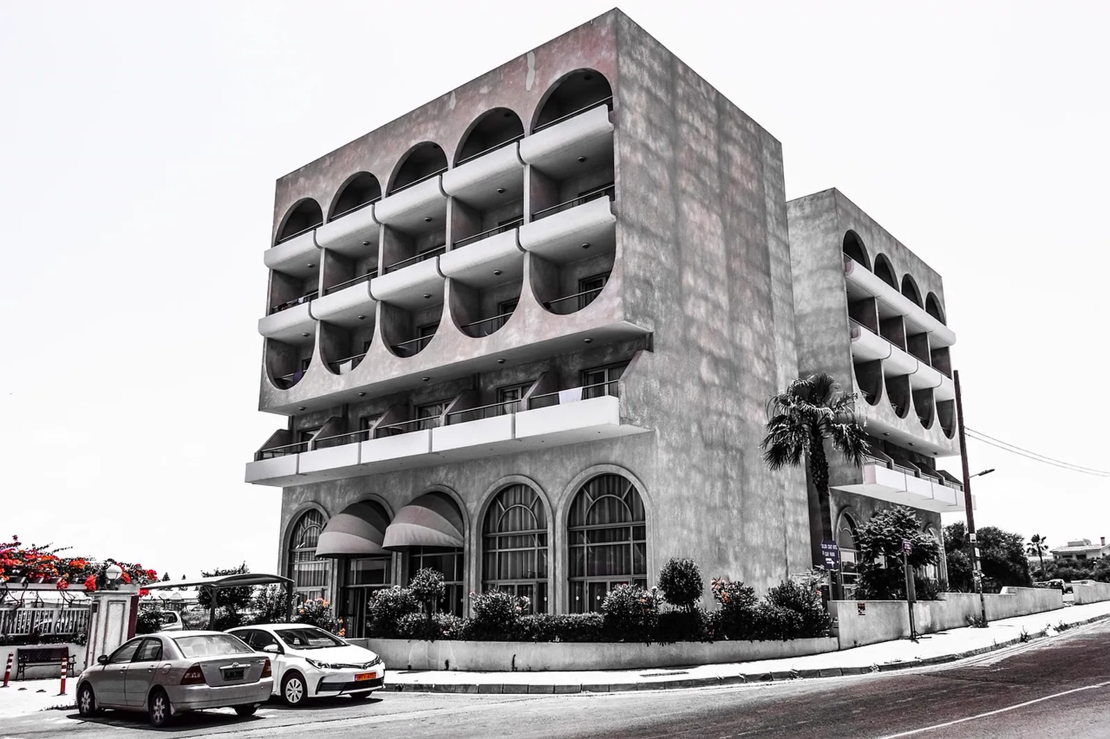 Universal Cabana Bay Beach Resort: A concrete hotel building with arched balconies stands on a street corner.